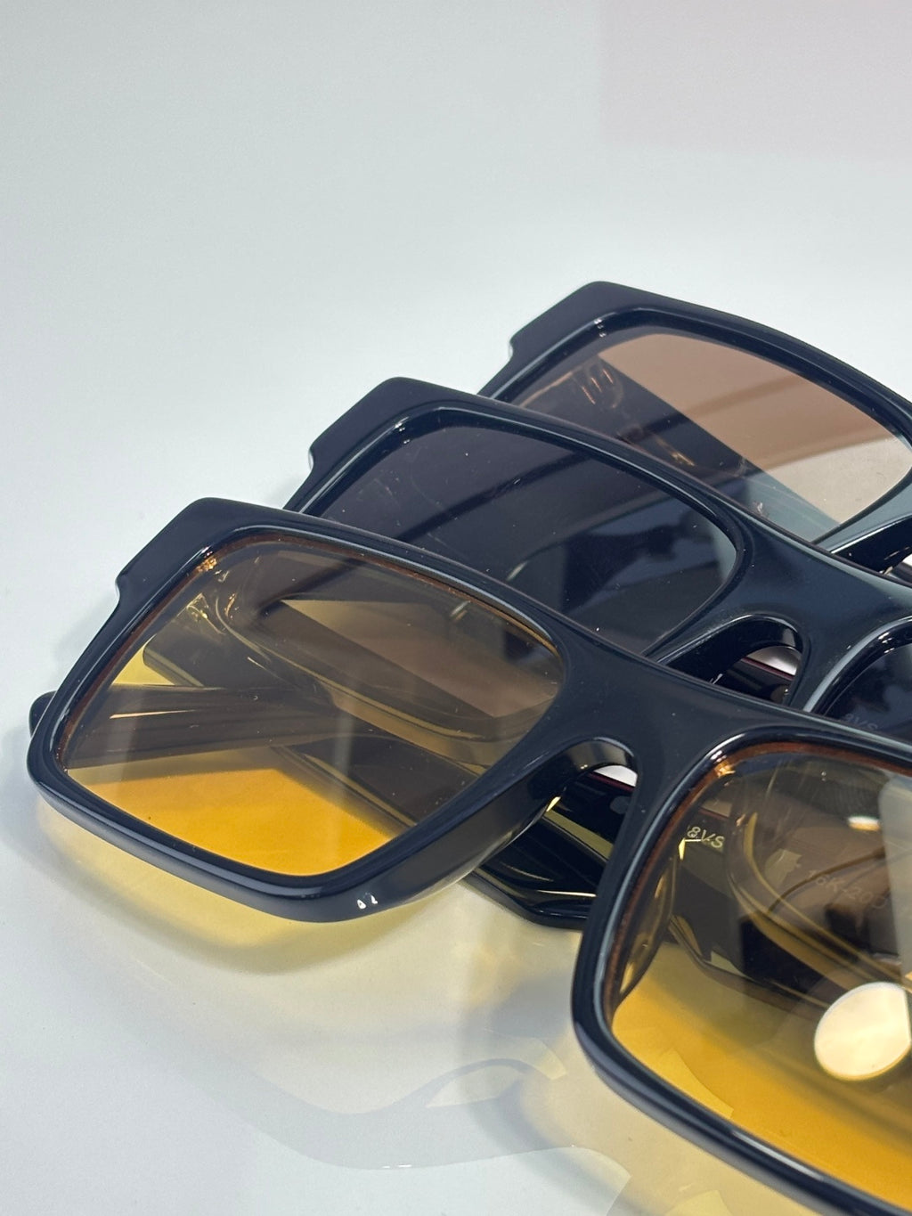 Prada square sunglasses close-up with dark frames and yellow-tinted lenses