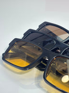 Prada square sunglasses close-up with dark frames and yellow-tinted lenses