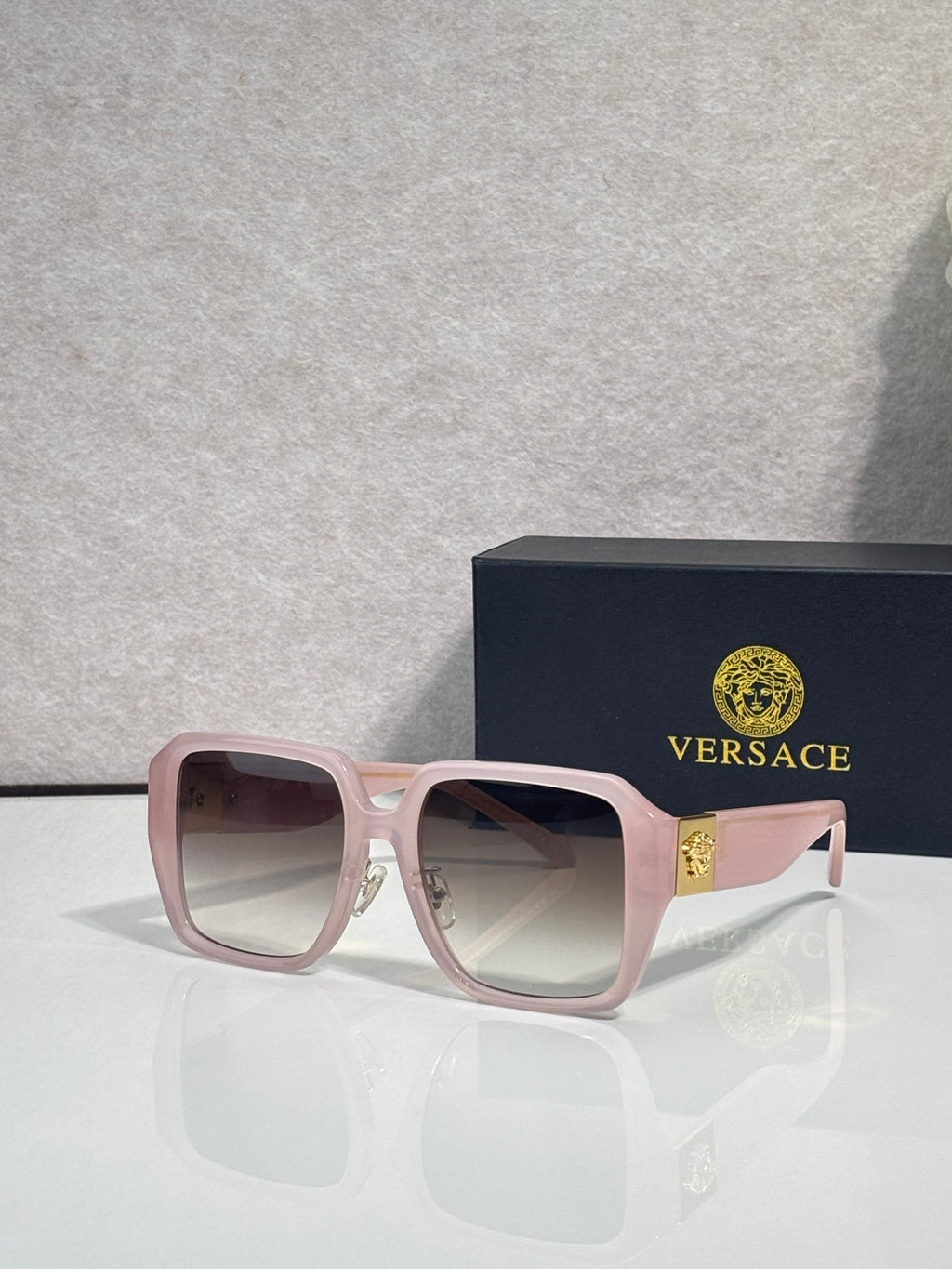 Versace square sunglasses with light pink frame and mauve tinted lenses, gold logo