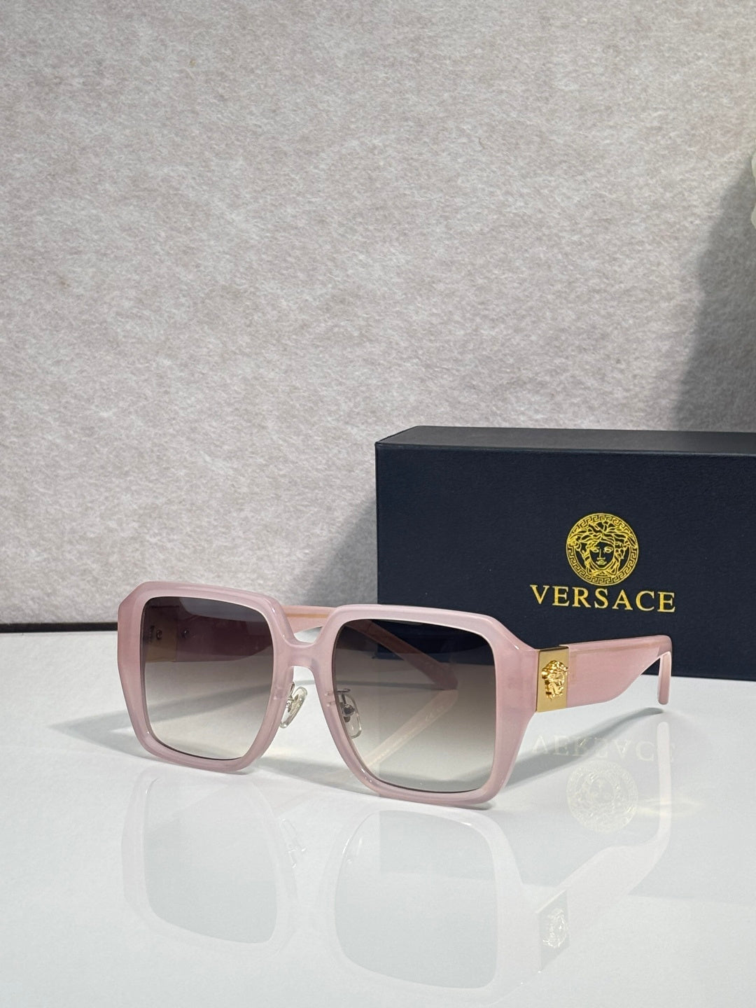 Versace square sunglasses with light pink frame and mauve tinted lenses, gold logo