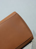 Brown leather tote bag corner with top-stitched edge and smooth grain finish