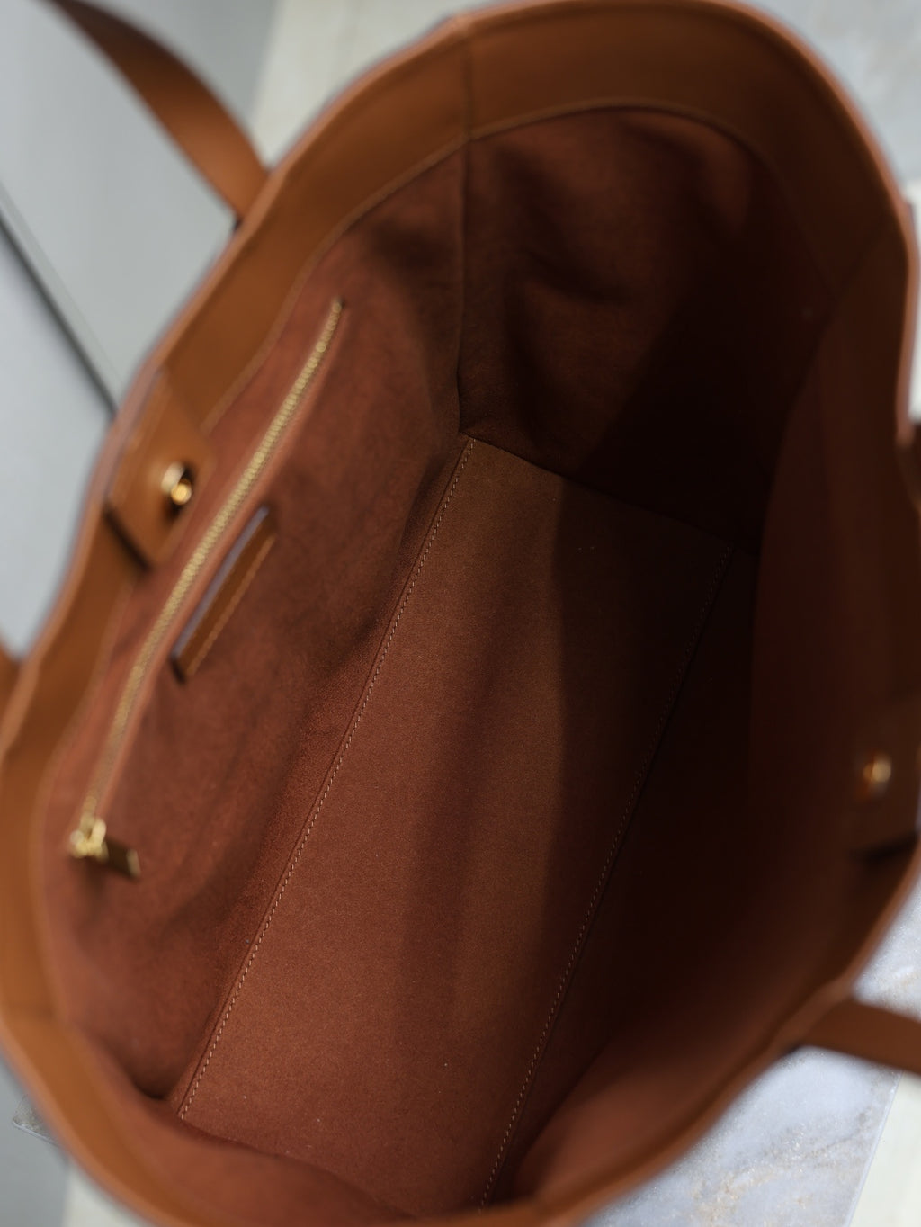 Brown leather tote bag interior with slip pocket and visible stitching seams