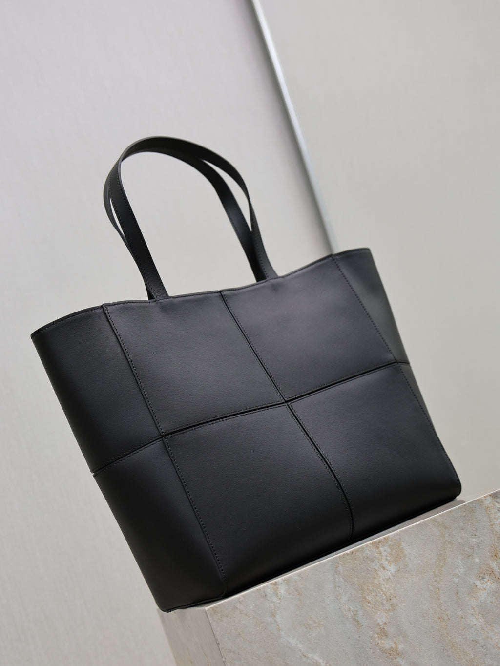YSL black tote bag, angled view, stitched panel front and top handles