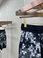 Pixel-check shorts with navy waistband, drawcord, and gold zipper pouch detail