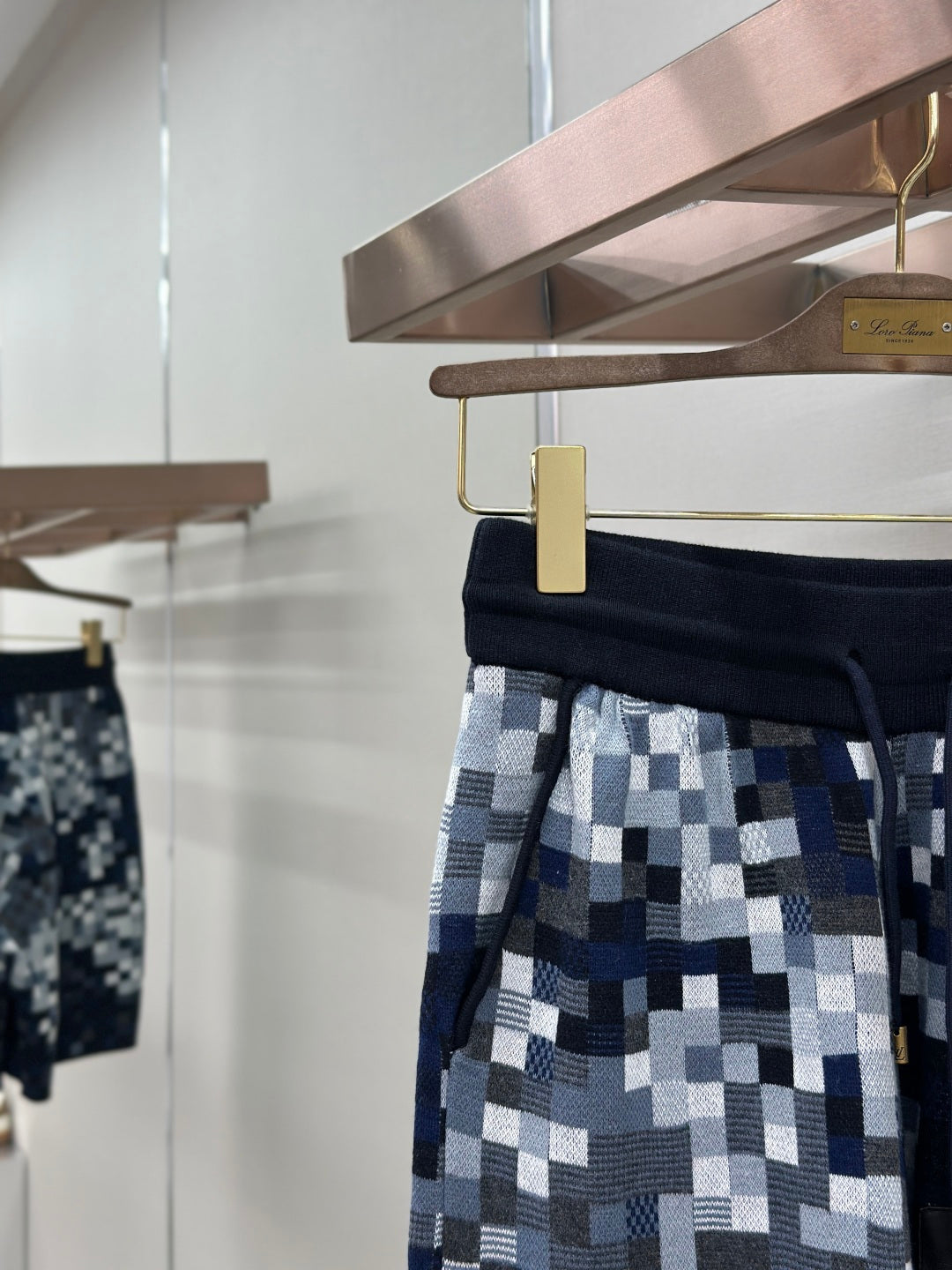 Pixel-check shorts with navy waistband, drawcord, and gold zipper pouch detail
