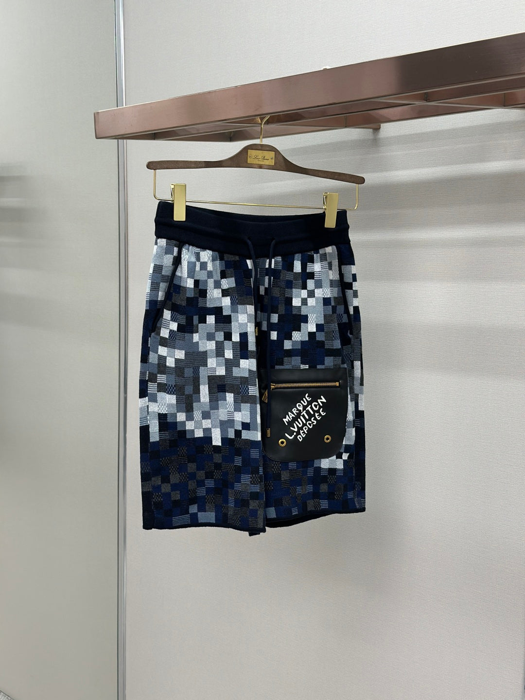 Blue and white pixel-check shorts with black waistband and drawcord
