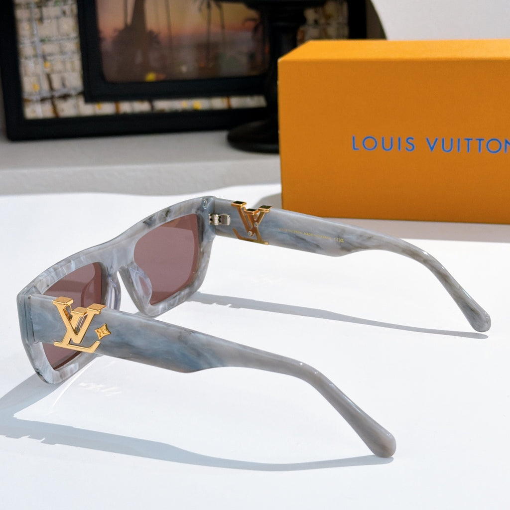 Side view sunglasses with translucent blue frames, pink lenses, gold LV logo.