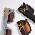 Sunglasses close-up: translucent light blue, black, and tortoiseshell frames with LV logos.