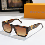 Sunglasses with tortoiseshell frames and amber lenses, gold LV logo on temples.