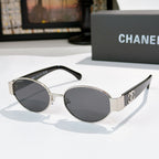Silver and black round sunglasses with dark lenses; Chanel logo on side temples.