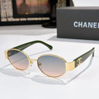 Gold-rim round sunglasses with pink-tinted lenses and green temples; Chanel logo on arms.