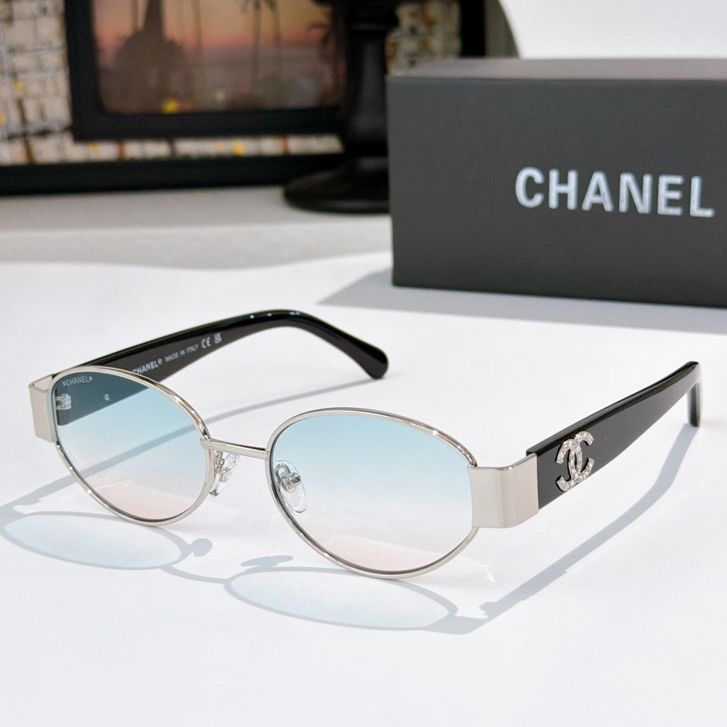 Silver-rim round sunglasses with blue-tinted lenses and black temples; Chanel logo detail.