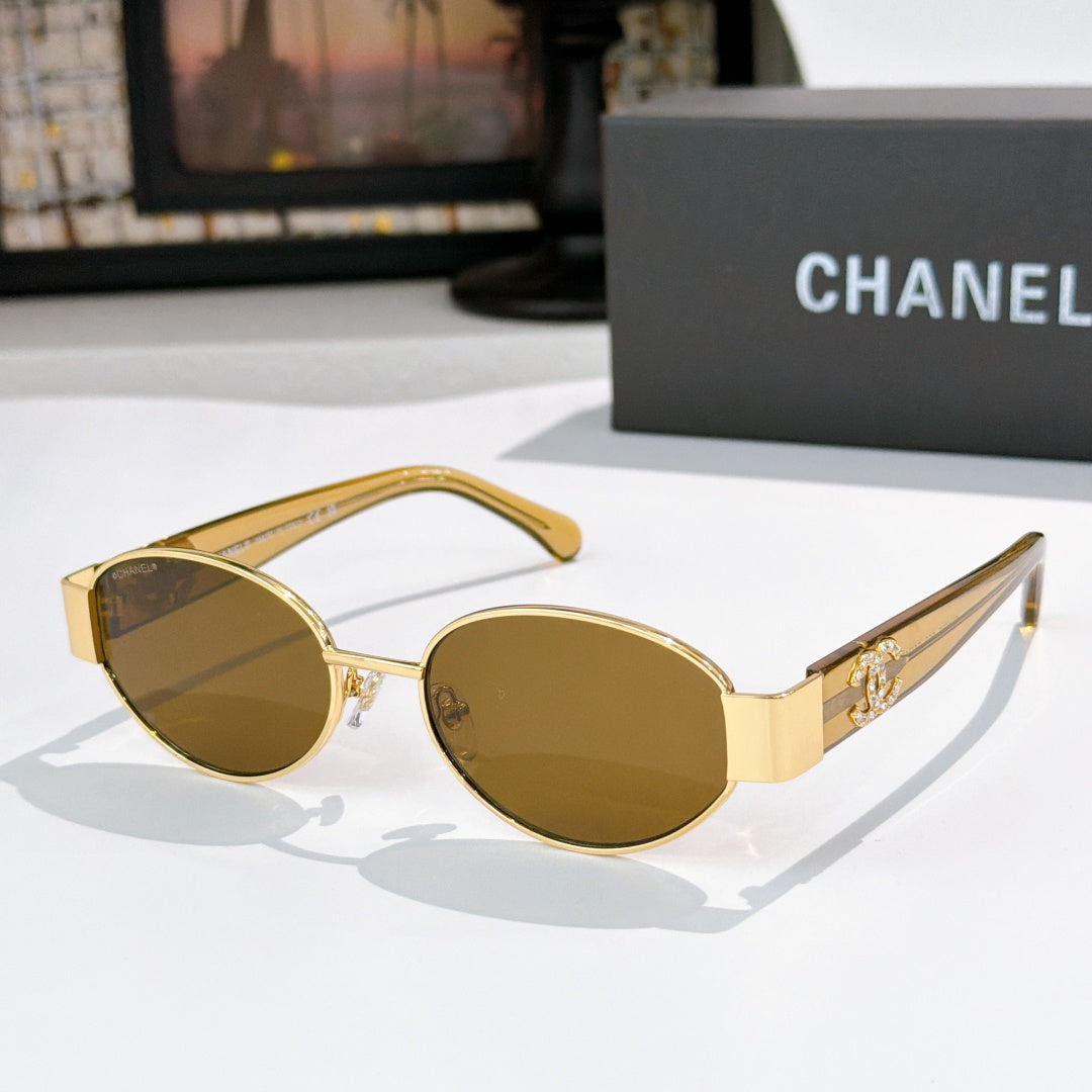 Gold round sunglasses with dark lenses and gold temples; Chanel logo on arms.