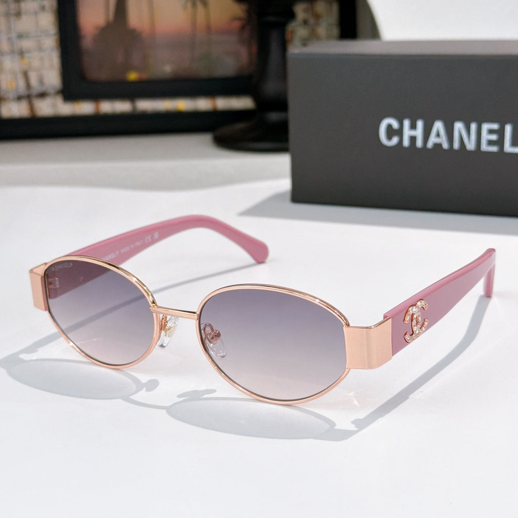 Rose-tinted round sunglasses with pink frames and gold accents; Chanel logo on arms.