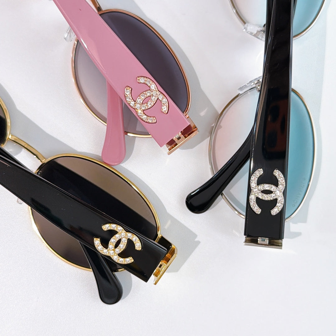 Close-up of sunglass temples with Chanel logo in pink, black, and dark frames.