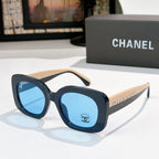 Chanel sunglasses with dark frame and blue tinted lenses, beige-tan arms and logo detail
