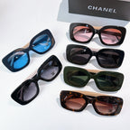 Chanel sunglasses assortment laid out, featuring pink, blue, green, and tortoise lens colors