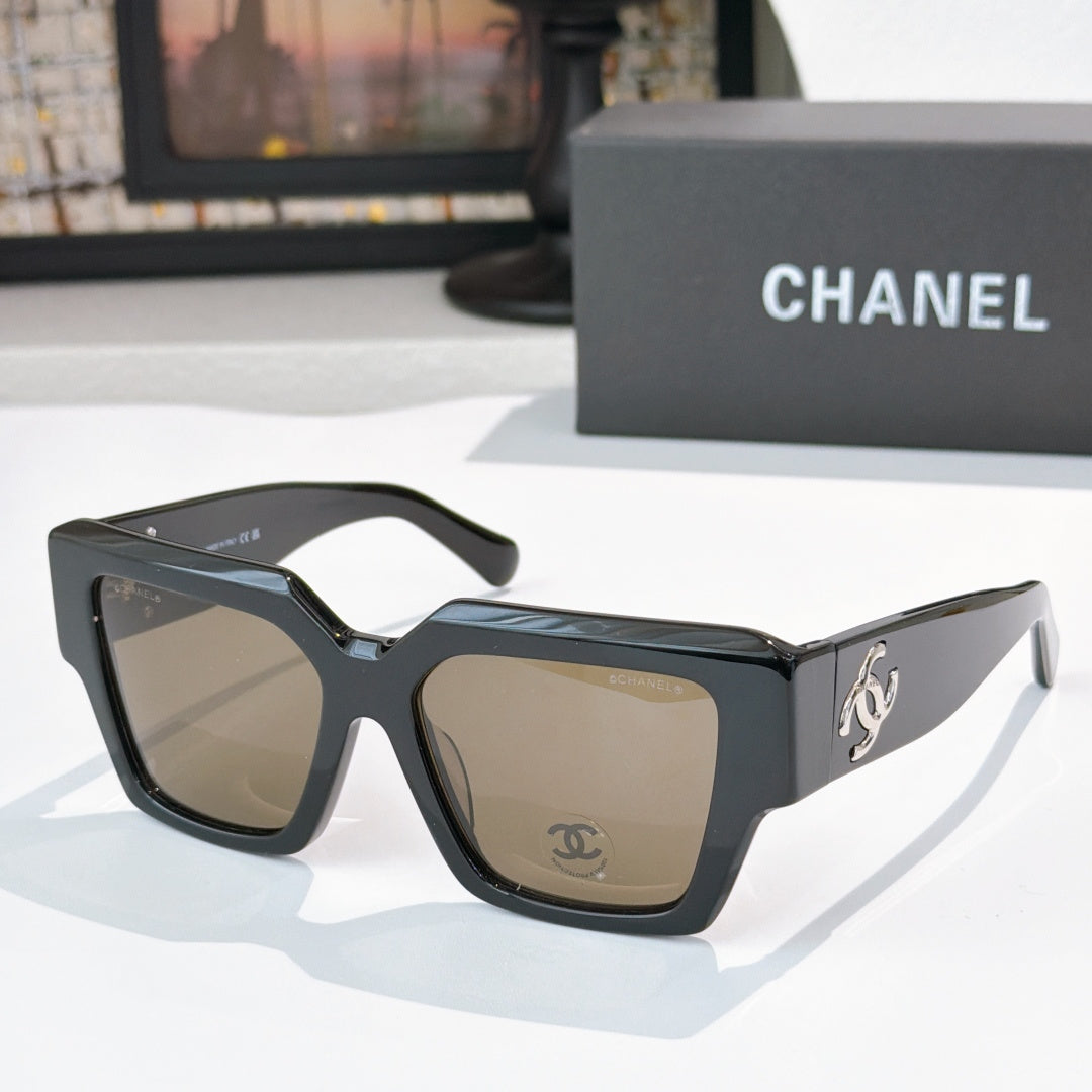Square black sunglasses with brown tinted lenses and silver logo detail