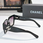 Oversized black sunglasses with purple tinted lenses and silver side logo