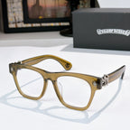 Gold-toned eyeglasses with white lenses and ornate gold-tone hinges.