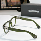 Green eyeglasses side view with ornate hinge and fleur-de-lis temple emblem.