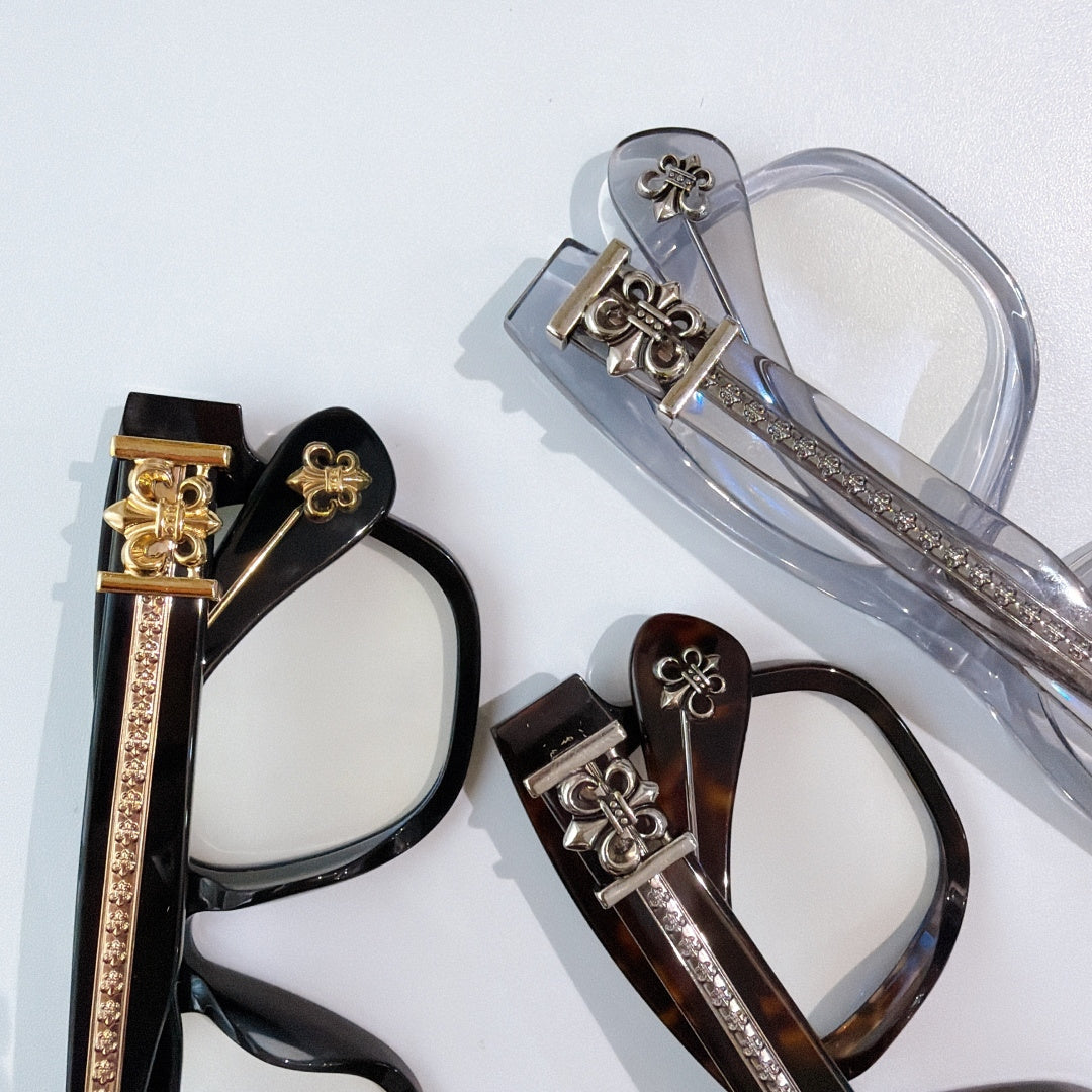 Assorted eyeglasses with decorative fleur-de-lis metal hinges and lens frames.