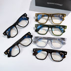 Assorted eyeglasses in black, blue, and tortoise frames with gold-tone hinges.