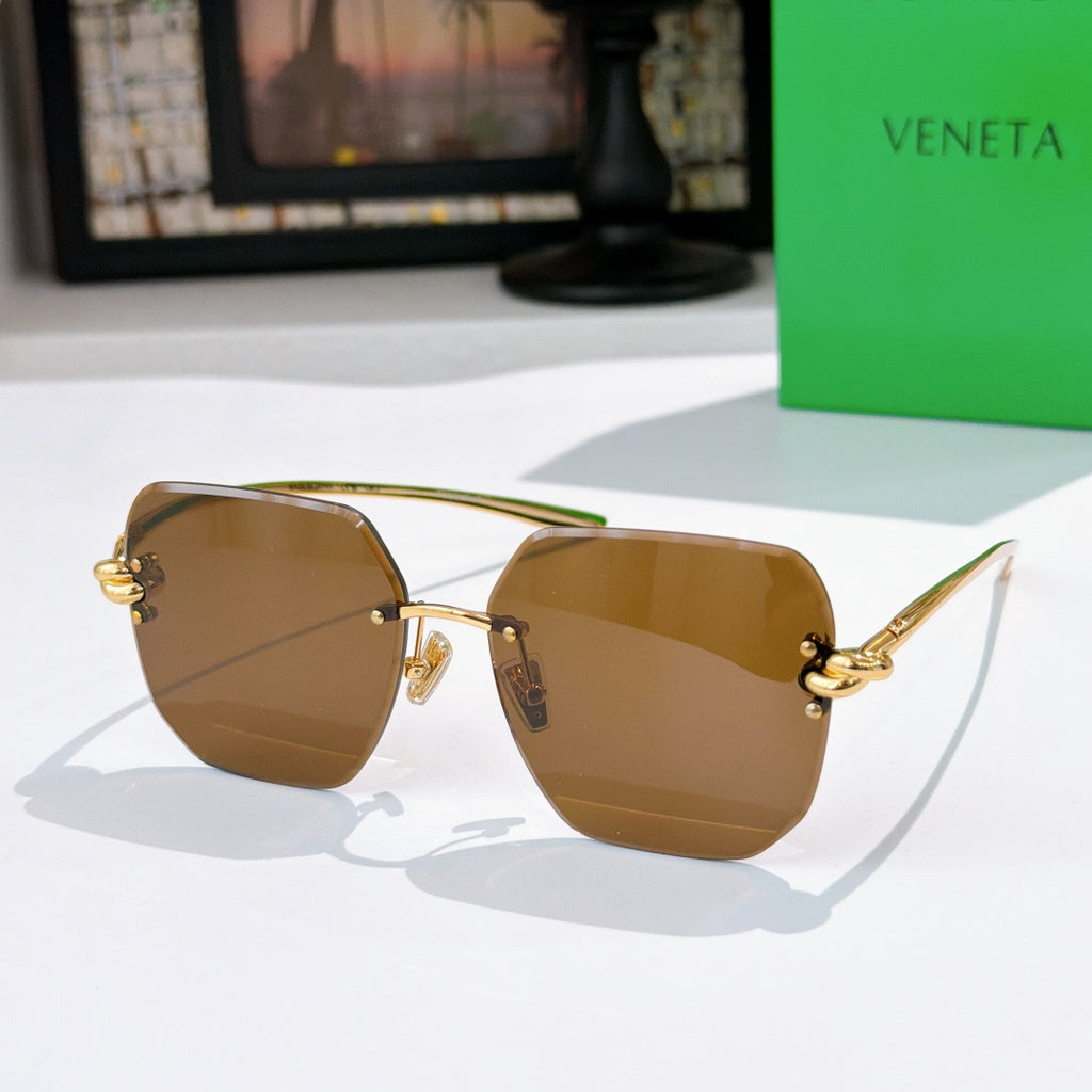 Bottega Veneta sunglasses, amber gradient lenses, gold-tone metal frame.