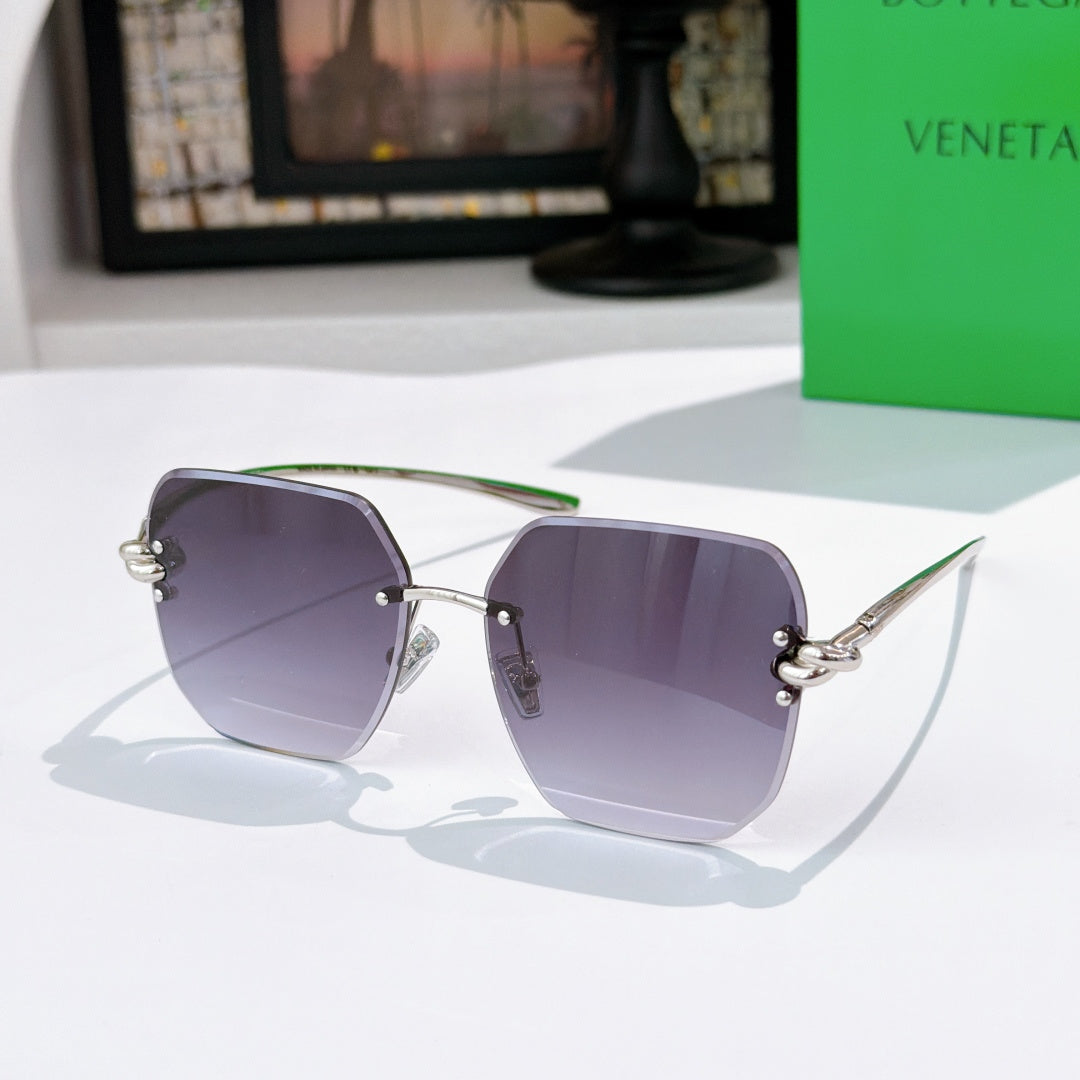 Bottega Veneta sunglasses, purple gradient lenses, gold-tone metal frame.