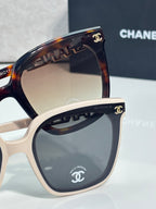 Cat-eye sunglasses with tortoiseshell upper frame and white front, gray lenses