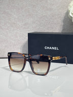 Square sunglasses with tortoiseshell frames and dark gray lenses, gold logo accent on temple