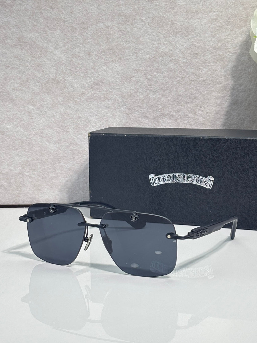Chrome sunglasses with dark blue lenses, black frame, and silver-tone hinges on temples.