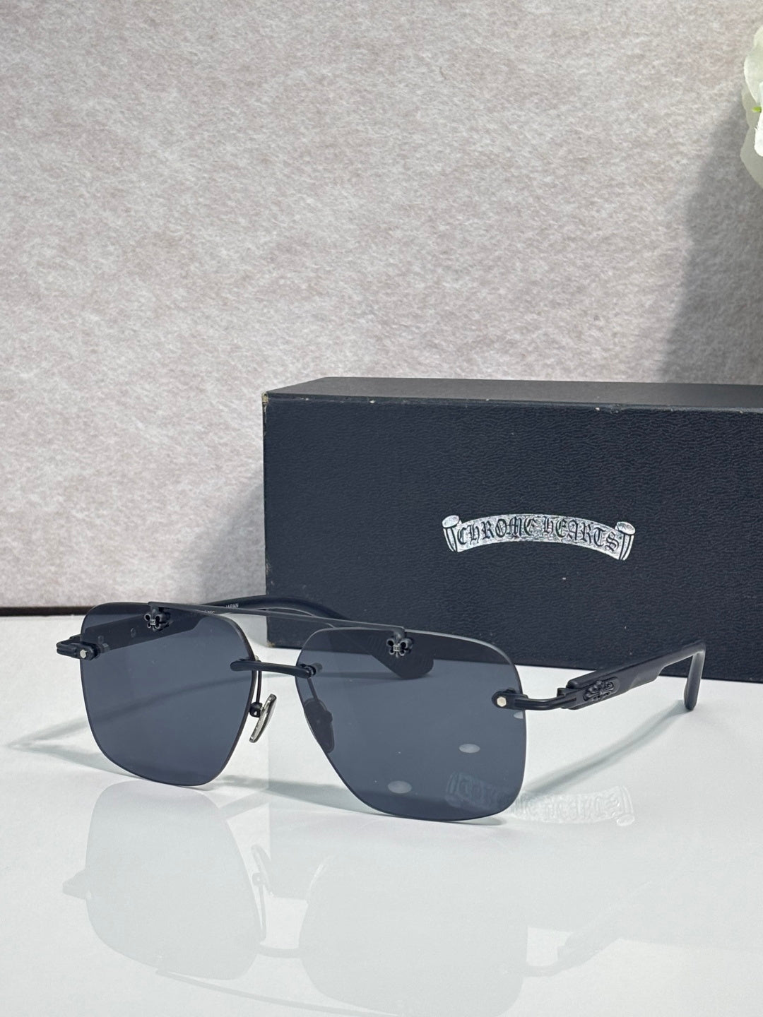 Chrome sunglasses with dark blue lenses, black frame, and silver-tone hinges on temples.