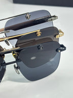 Stacked chrome sunglasses with dark blue lenses, metal frames, and gold-tone hinge embellishments.