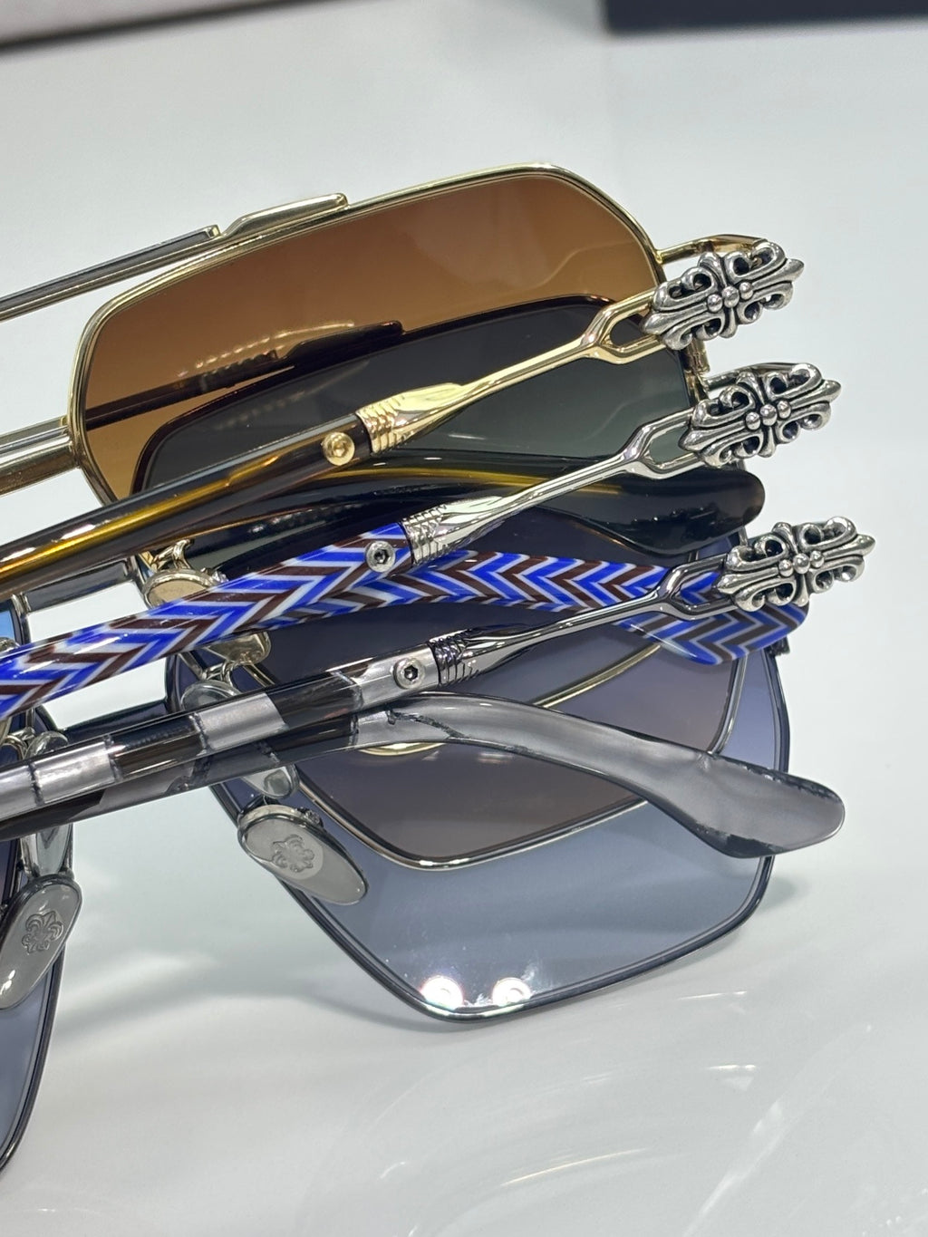 Sunglasses close-up with gold-tone frame, patterned temples, and ornate bridge detail