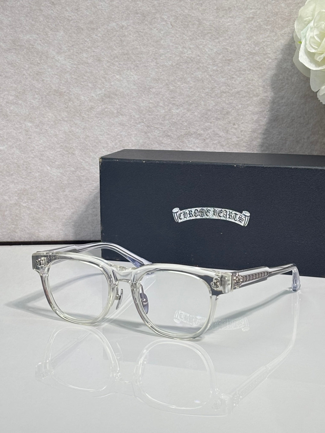 Silver clear-framed glasses with round lenses and small decorative hinge details