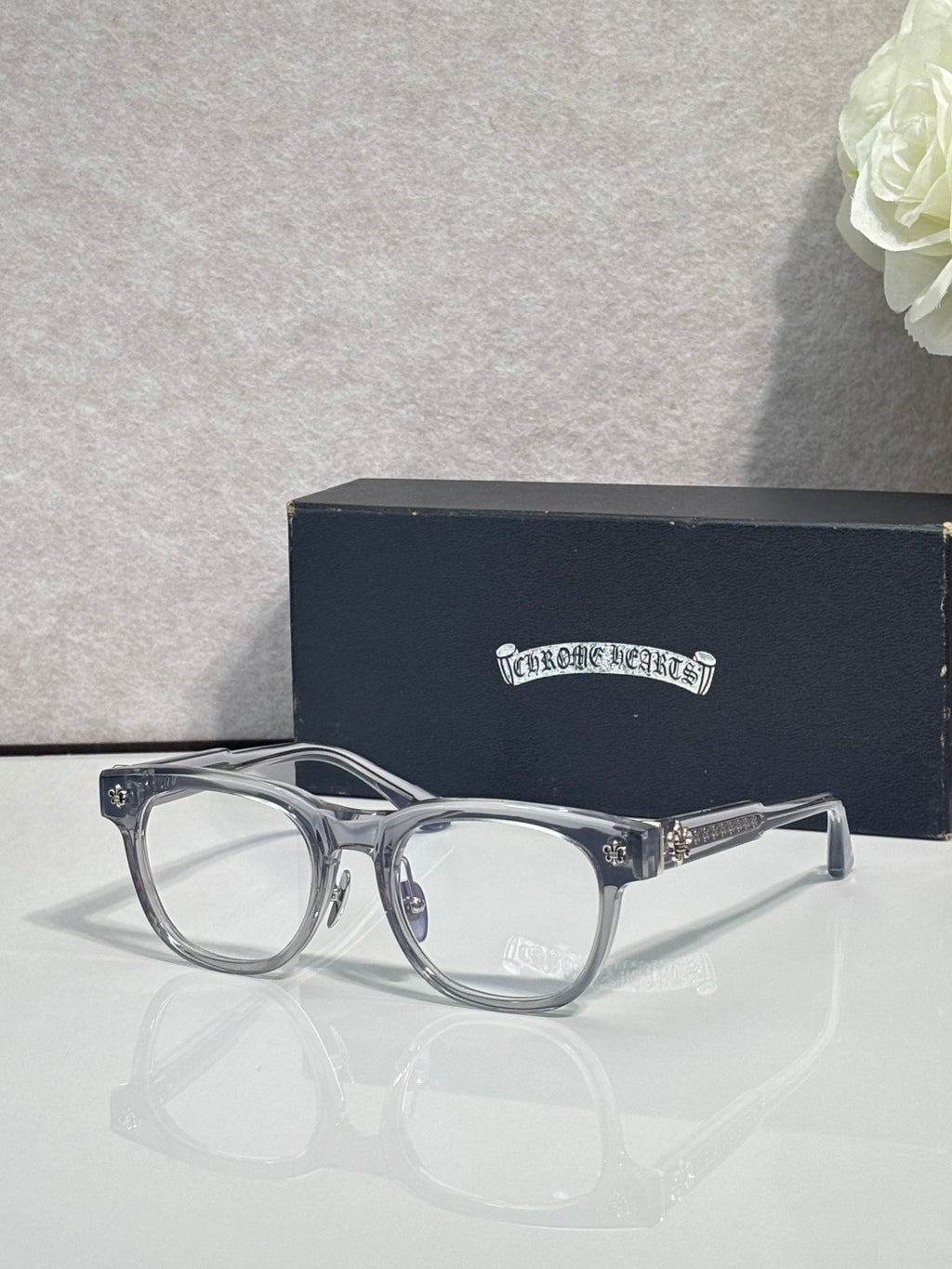 Clear eyeglasses with metal frame accents and ornate silver-tone temple details