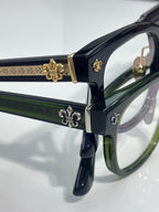 Dark blue glasses with green inner accents, gold fleur-de-lis temple hardware
