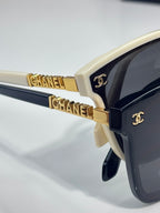 Chanel sunglasses close-up: gold CHANEL logo on black temple with dark lens
