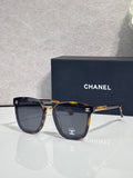 Chanel sunglasses with dark lenses, tortoiseshell frame, and gold logo temple details