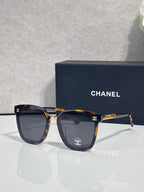 Chanel sunglasses with dark lenses, tortoiseshell frame, and gold logo temple details