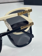 Chanel sunglasses close-up: cream temple with gold CHANEL logo and dark lens