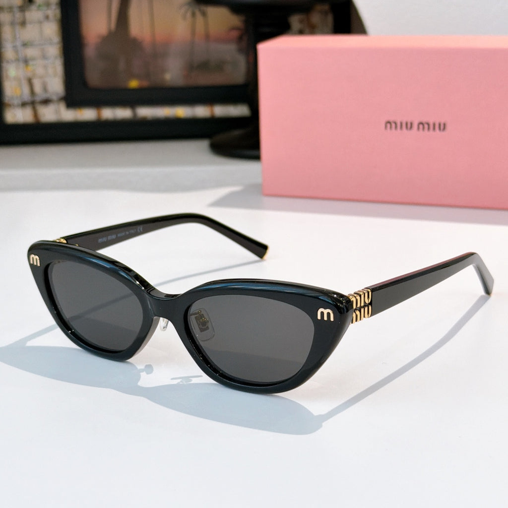 Dark cat-eye sunglasses with dark lenses and gold-tone temple logo accents
