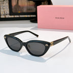 Dark cat-eye sunglasses with dark lenses and gold-tone temple logo accents
