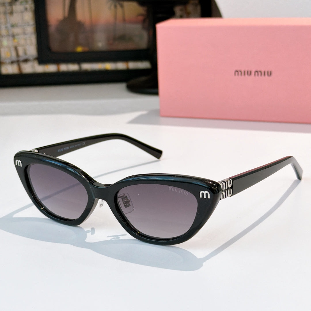 Dark cat-eye sunglasses with purple-brown lenses and gold-tone temple logo accents