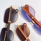 Assorted sunglasses with gold hinges, featuring black, blue, and brown frames.