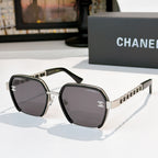 Black sunglasses with dark tinted lenses and gold chain-style temples.
