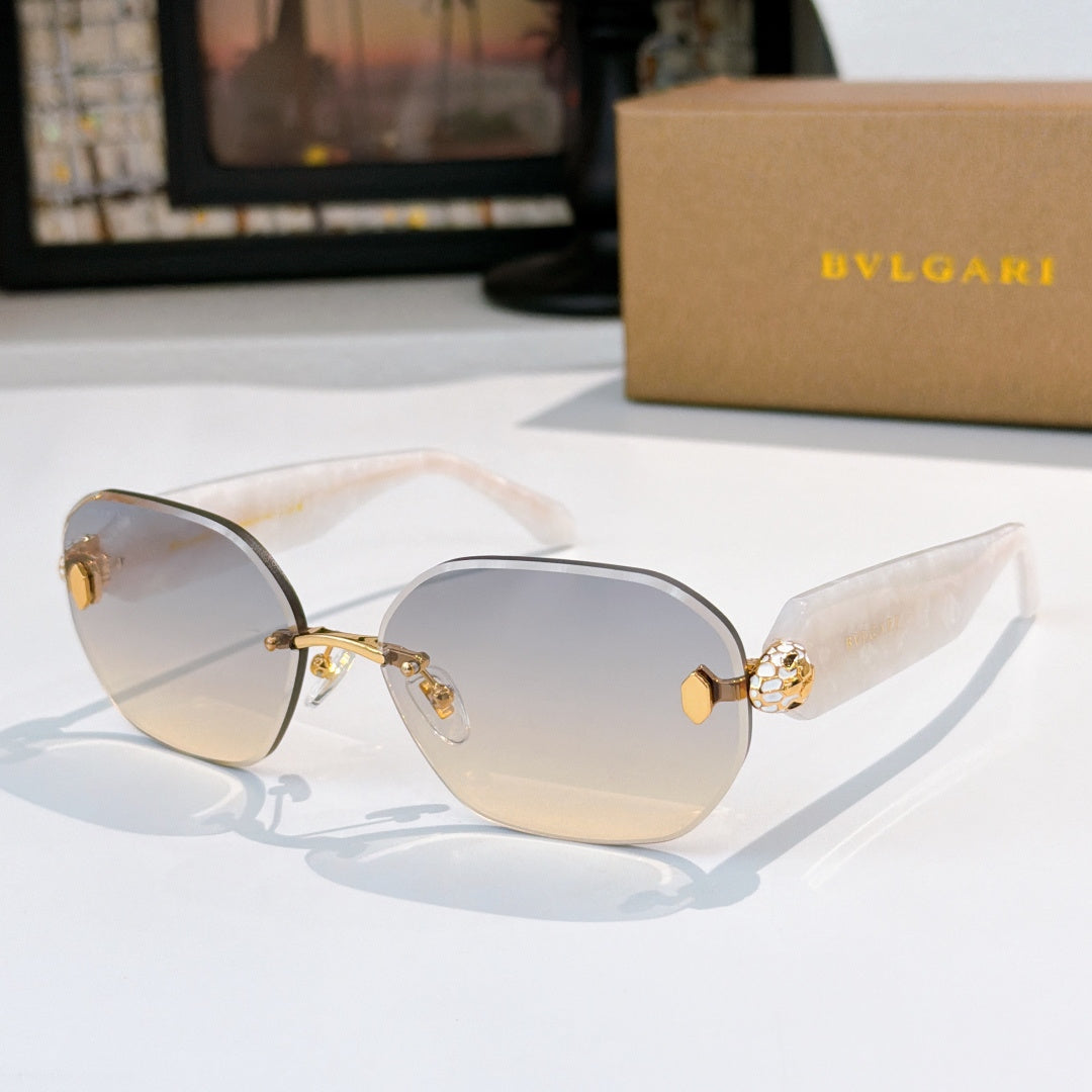 Light-colored sunglasses with blue-tinted gradient lenses and gold emblem temple detail.