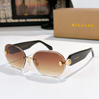 Gold sunglasses with brown gradient lenses and embossed temple logo detail.