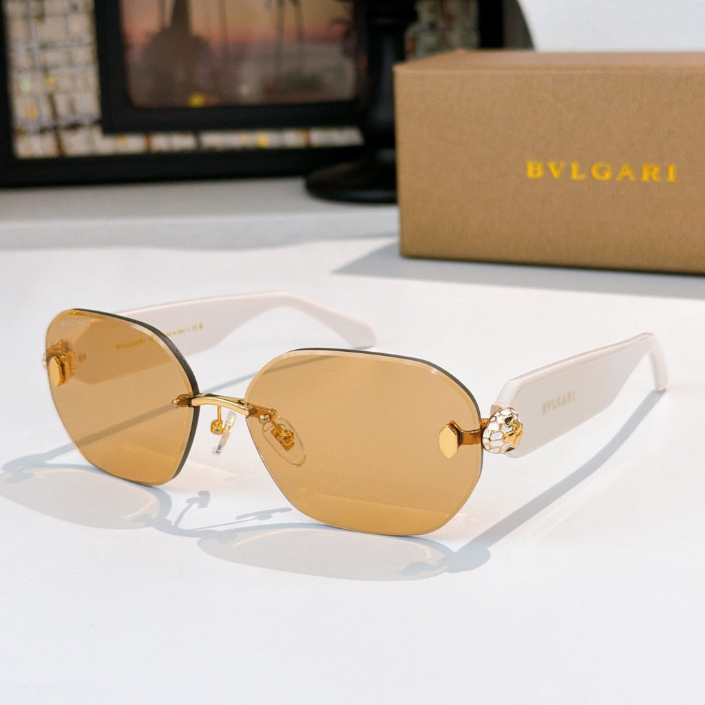 Gold sunglasses with amber-tinted lenses and gem-like emblem on the temple.